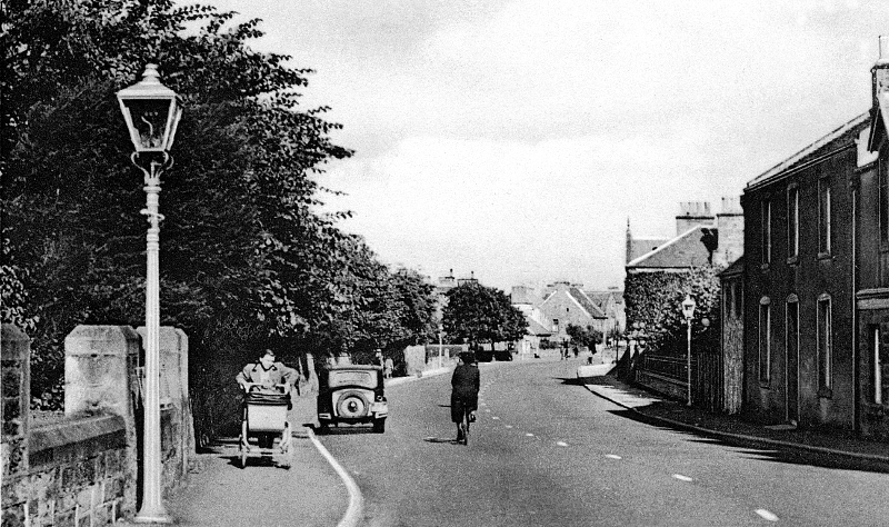 High Street, Aberlady, c1940s. The trees on the left are those of ‘Glebe House’, and the railings of ‘The Lodge’ can be seen on the right, in the middle distance.